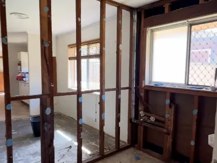 A room stripped back to bare timber studs after the old lining came out, cleared and ready for new plasterboard to be hung and set.